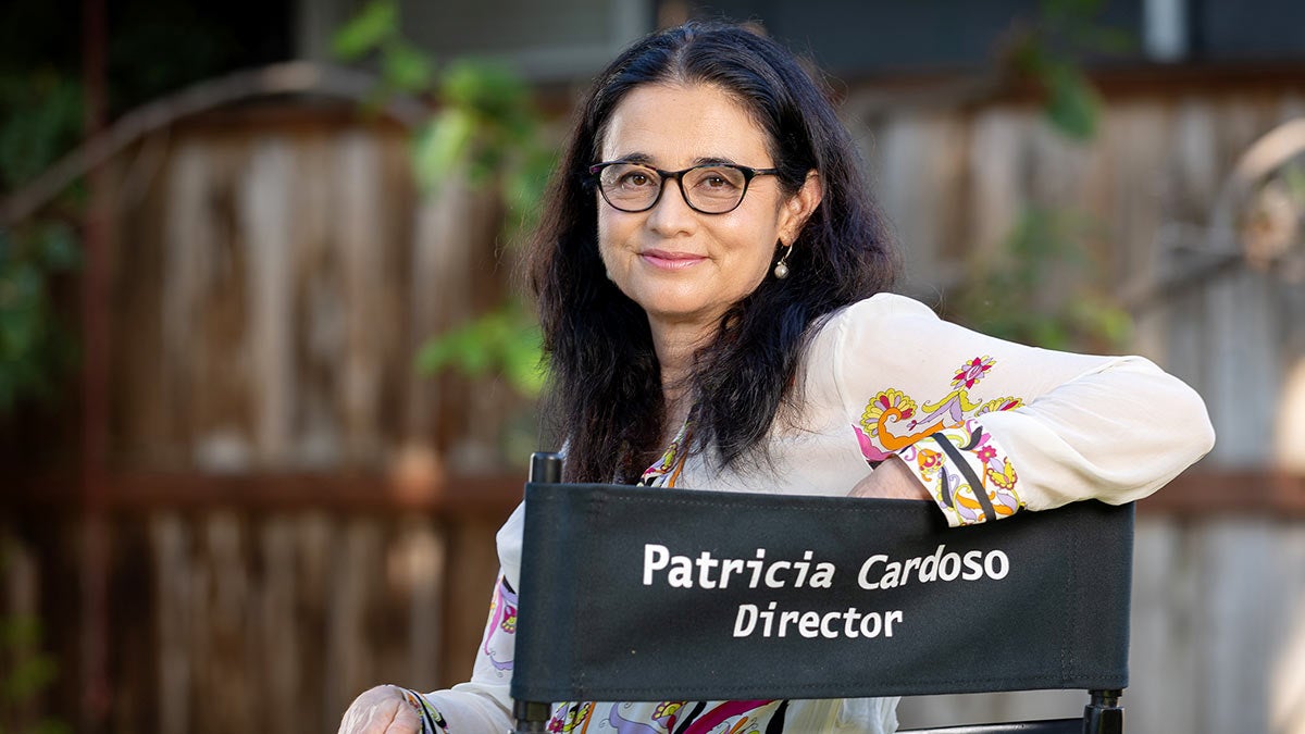Patricia Cardoso sits sideways in a director's chair with her name.