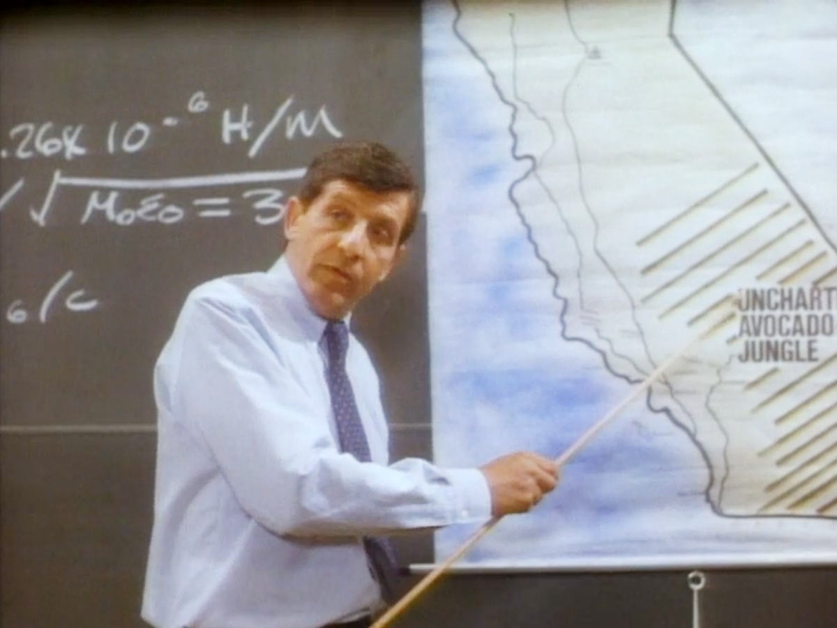 Still from the movie 'Cannibal Women in the Avocado Jungle of Death', where a professor shows a map of the avocado jungle.