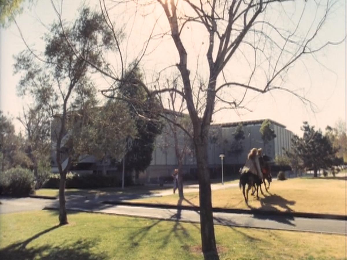 Still from the movie 'Genesis II', showing horse riders in front of Pierce Hall.