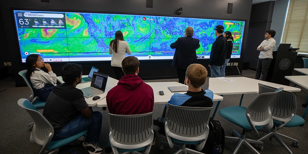 Students in a classroom with a large widescreen display