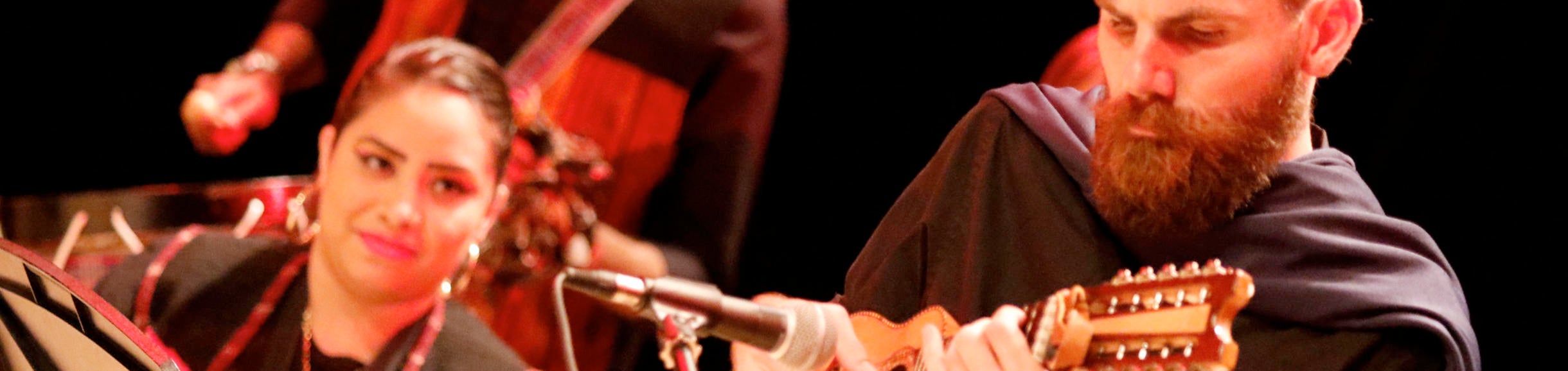 man and woman on stage play guitars