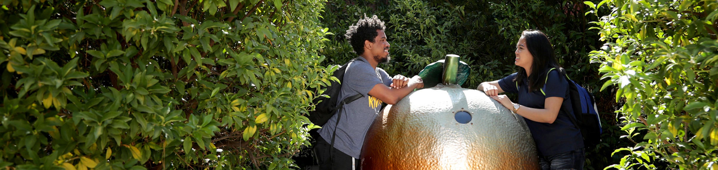 Students talking in front of orange statue