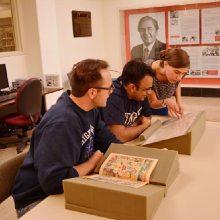 students looking at old archives in the special collections library