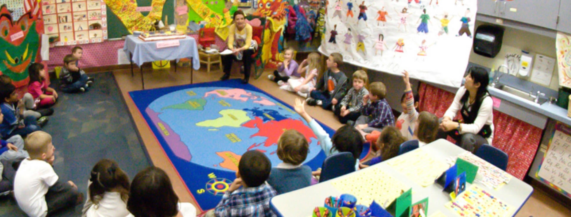 children playing on rug with a photo of the world on it