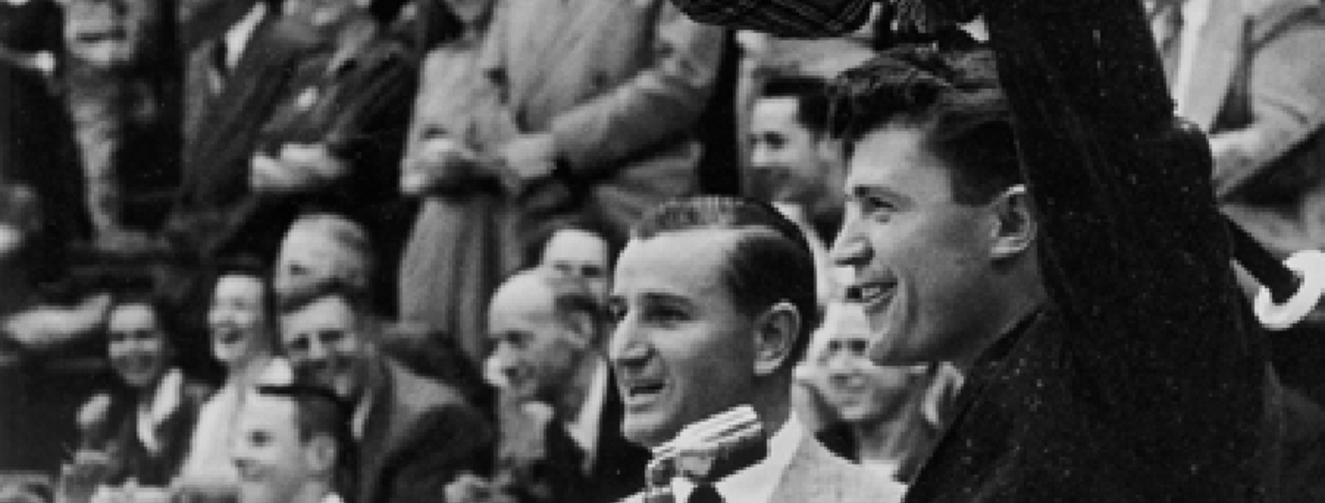 students from the 1950's cheering in black and white photo