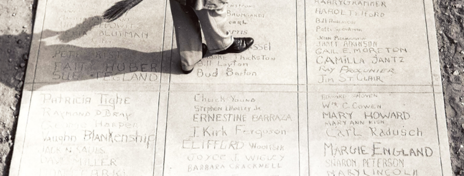 names carved into pavement with someone walking on it